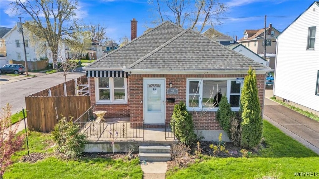 98 Victoria Blvd, Tonawanda-Town, NY 14217 - bungalow-style house featuring roof with shingles, fence, a residential view, brick siding, and a chimney