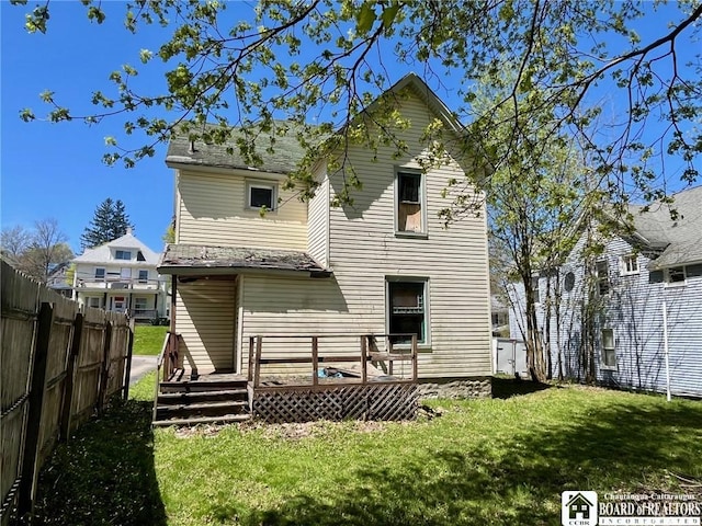 back of house featuring a yard, fence, and a wooden deck