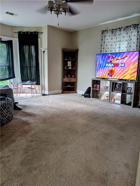 living room featuring ceiling fan, carpet, and baseboards