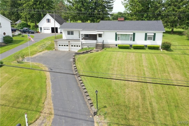 5567 W Lake Rd, Fleming, NY 13021 - view of front of house featuring a detached garage, a chimney, a front yard, and aphalt driveway