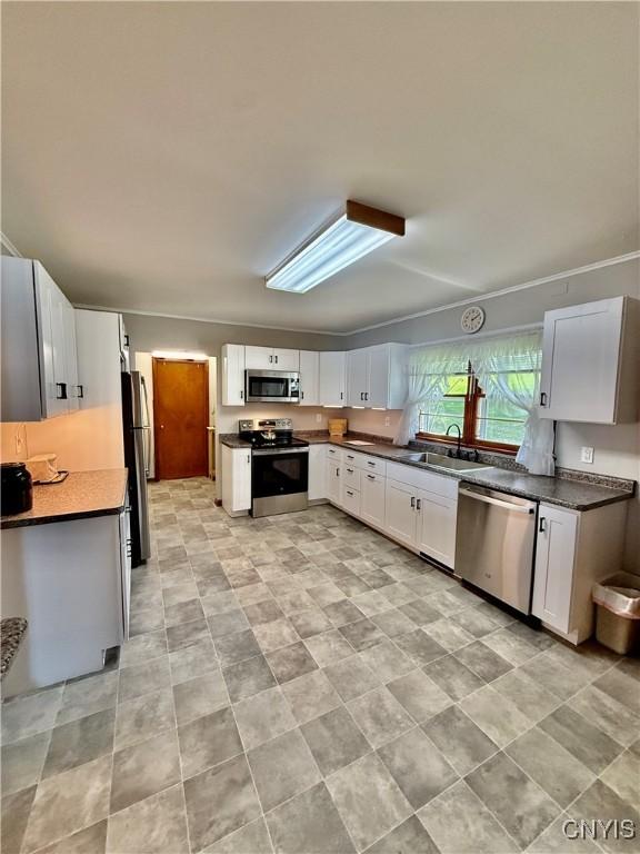 5567 W Lake Rd, Fleming, NY 13021 - kitchen with a sink, dark countertops, white cabinets, and stainless steel appliances