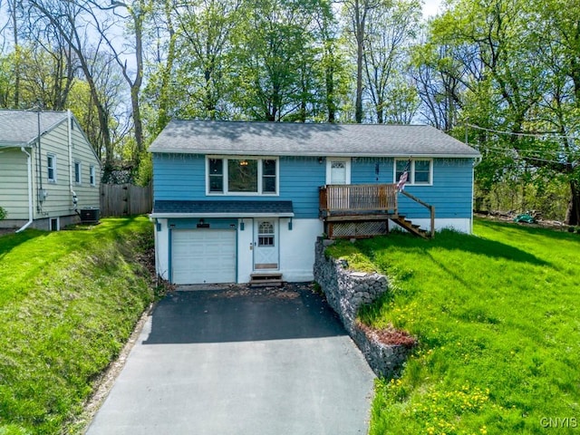 view of front of property with a garage, aphalt driveway, a front yard, a deck, and central air condition unit