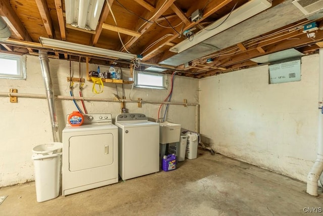 below grade area featuring a healthy amount of sunlight, a sink, and washer and clothes dryer