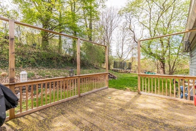 wooden terrace with a lawn and a trampoline