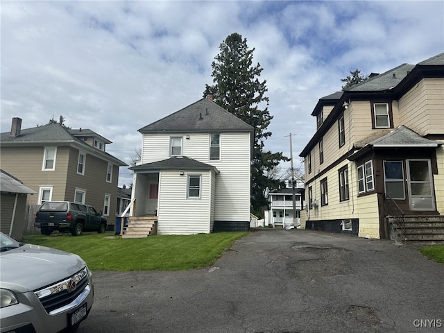 view of front of property with entry steps and a front lawn