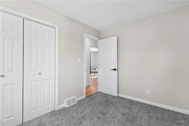 407 Montrose Ave, Geddes, NY 13219 - unfurnished bedroom with baseboards, a closet, dark colored carpet, and visible vents