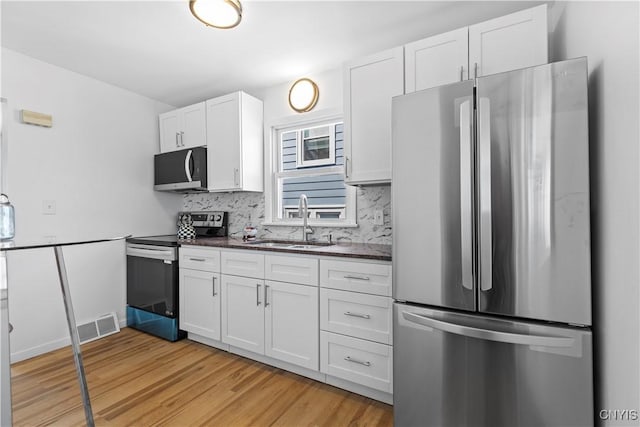 407 Montrose Ave, Geddes, NY 13219 - kitchen with visible vents, appliances with stainless steel finishes, dark countertops, a sink, and light wood finished floors