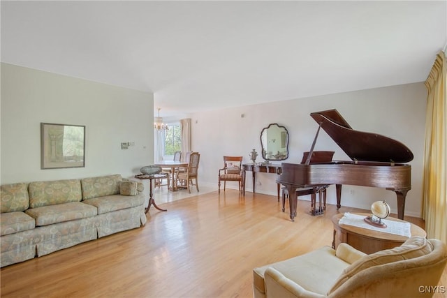 living area featuring light wood-style floors, baseboards, and a chandelier