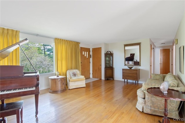 living area with baseboards and wood finished floors