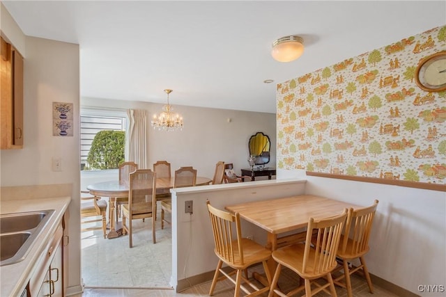 dining area with an inviting chandelier, wainscoting, and wallpapered walls