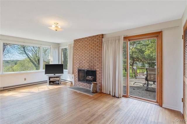 unfurnished living room featuring baseboard heating, a baseboard radiator, wood-type flooring, and a brick fireplace