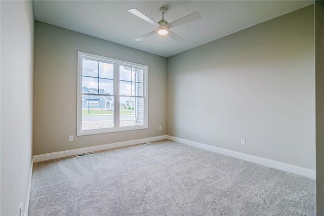 spare room featuring carpet floors, baseboards, and a ceiling fan