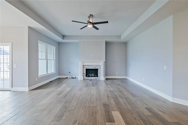 unfurnished living room featuring baseboards, ceiling fan, and wood finished floors