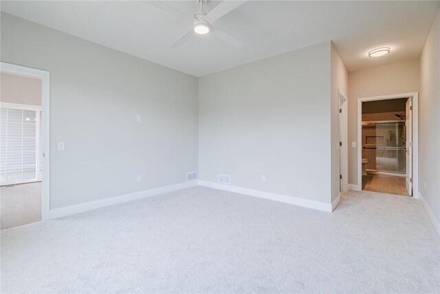 empty room with a ceiling fan, baseboards, light colored carpet, and visible vents