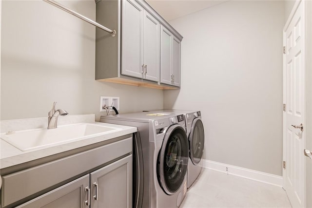 laundry area featuring baseboards, a sink, cabinet space, and washing machine and dryer