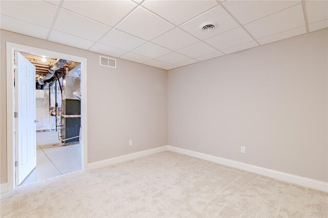 spare room with carpet flooring, visible vents, and a paneled ceiling