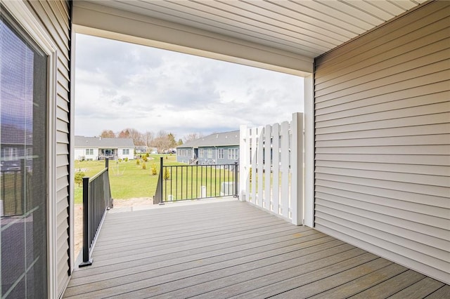 wooden deck featuring a residential view and a yard
