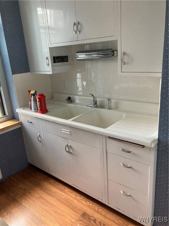 731 W Fry Unit 7G, Buffalo, NY 14222 - kitchen featuring light countertops, light wood finished floors, backsplash, and wallpapered walls