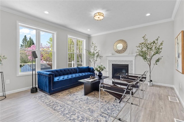 living area with visible vents, baseboards, wood finished floors, and a wealth of natural light