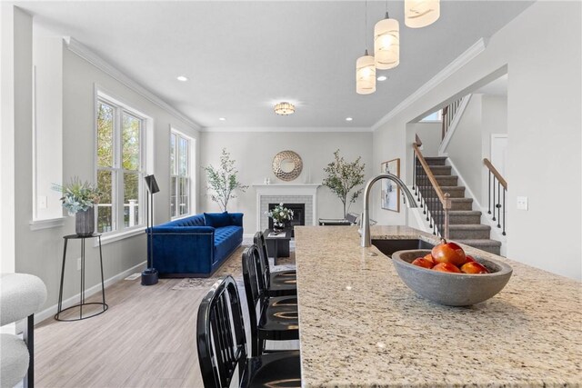 dining space with crown molding, a fireplace, recessed lighting, light wood-type flooring, and stairway