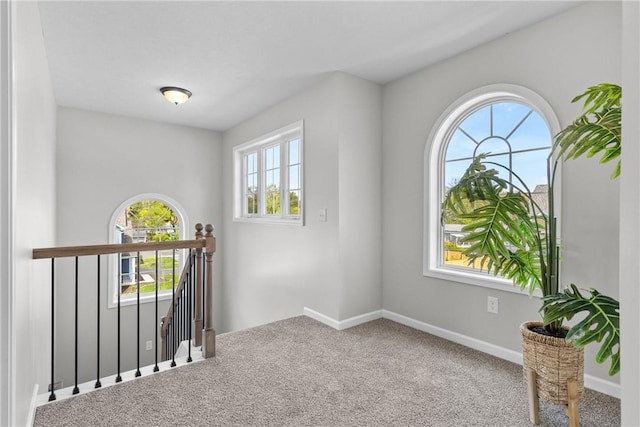 carpeted spare room featuring baseboards