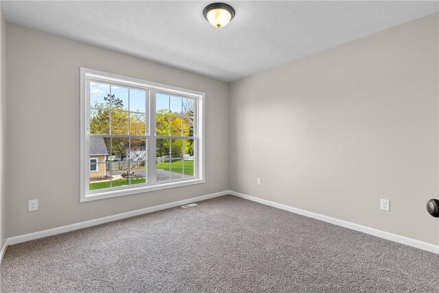 carpeted empty room with baseboards and visible vents