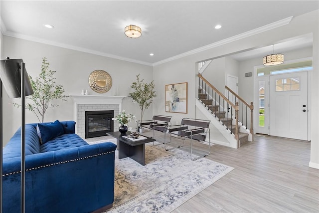 living area featuring stairs, recessed lighting, wood finished floors, and a fireplace