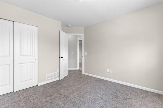 unfurnished bedroom with baseboards, visible vents, carpet, and a closet
