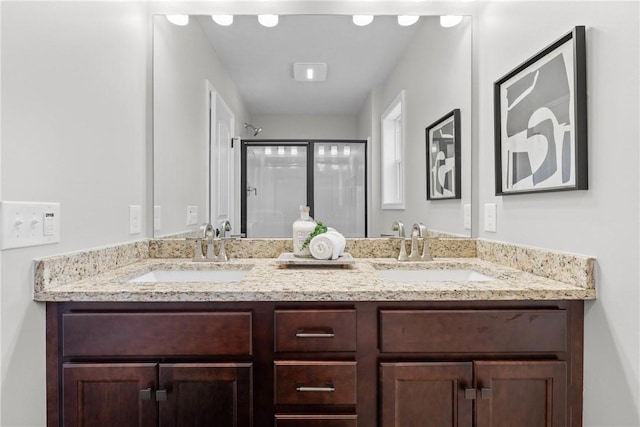 full bathroom with double vanity, a sink, and a stall shower