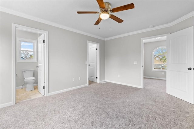 unfurnished bedroom with crown molding, baseboards, ensuite bathroom, and light carpet