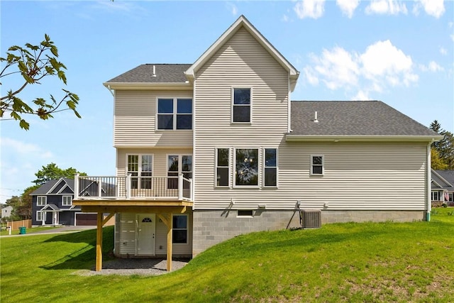 back of house featuring a lawn, a wooden deck, and roof with shingles