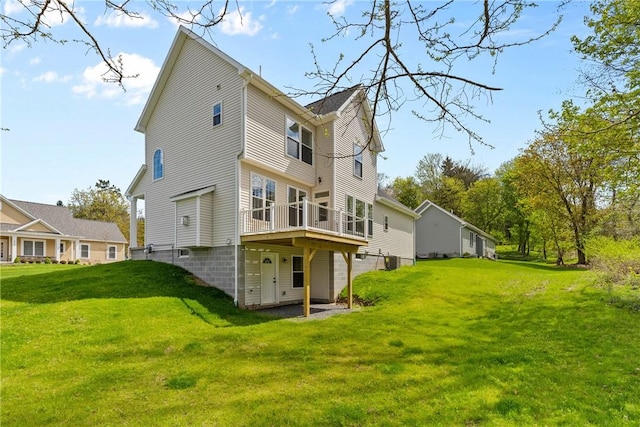 rear view of house with a lawn, central AC, and a deck