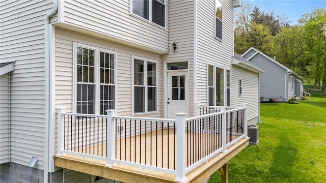 wooden terrace featuring a lawn and central air condition unit