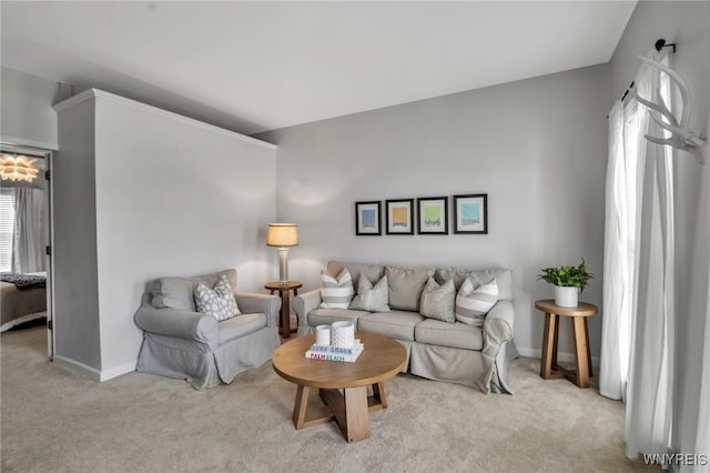 living area with baseboards and light colored carpet