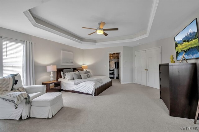 bedroom featuring crown molding, a ceiling fan, light carpet, and a tray ceiling