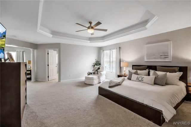 bedroom with ceiling fan, decorative columns, a raised ceiling, baseboards, and carpet flooring