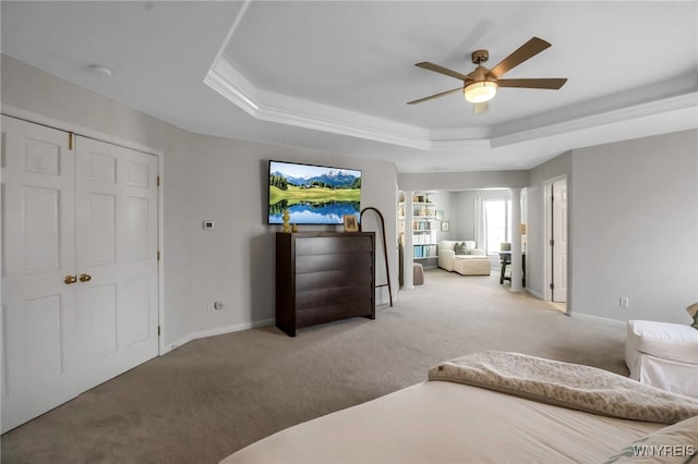 carpeted bedroom with baseboards, a ceiling fan, and a tray ceiling