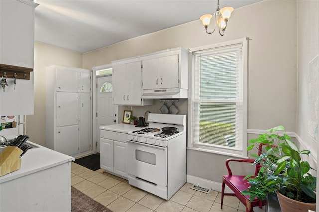 kitchen with a notable chandelier, white range with gas stovetop, white cabinetry, and under cabinet range hood