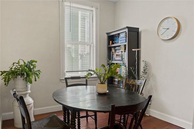 dining space with baseboards and wood finished floors