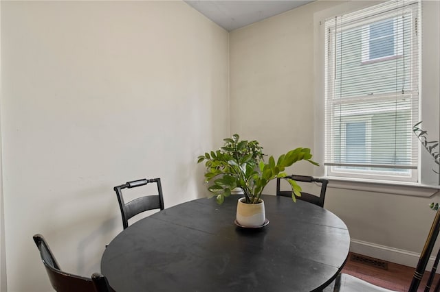 dining space featuring baseboards and wood finished floors
