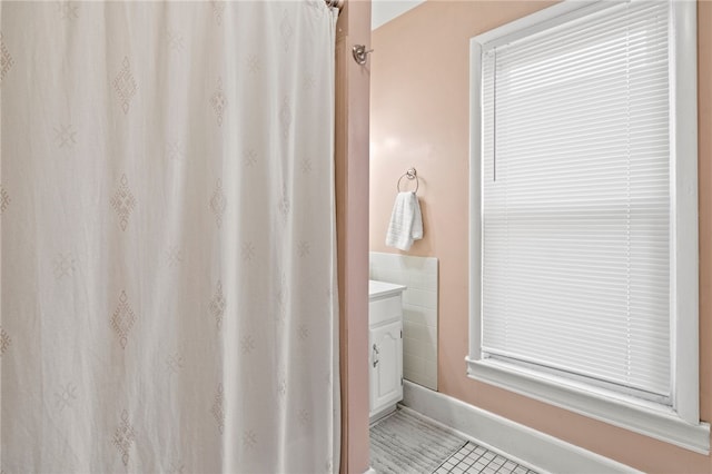 full bathroom featuring vanity, baseboards, a shower with curtain, and tile patterned flooring