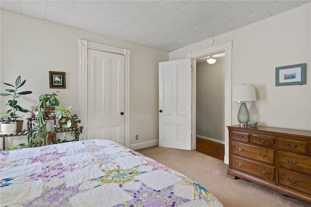 carpeted bedroom with baseboards and a closet