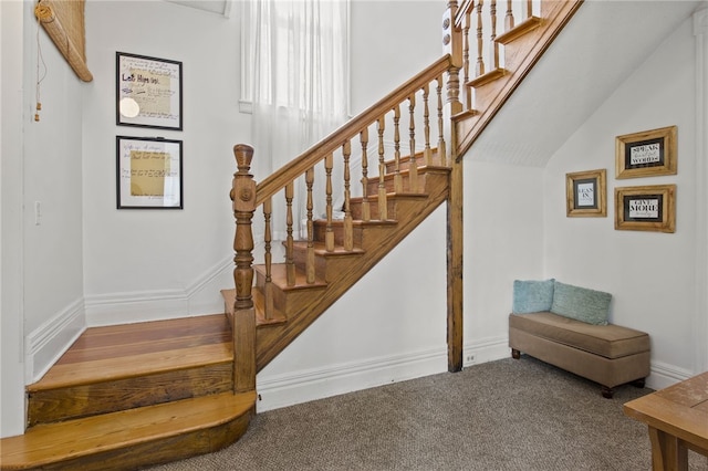 staircase with baseboards and carpet