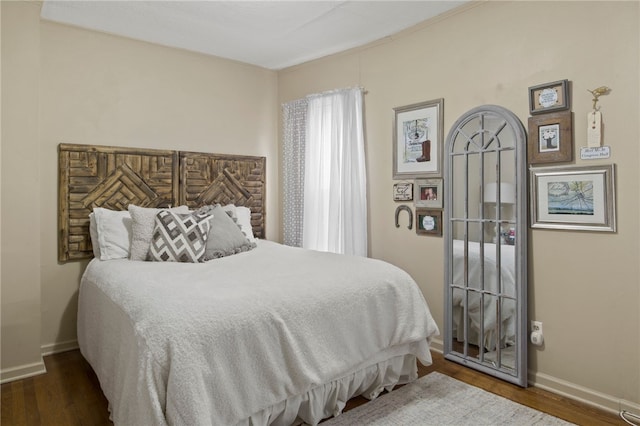 bedroom with baseboards and wood finished floors