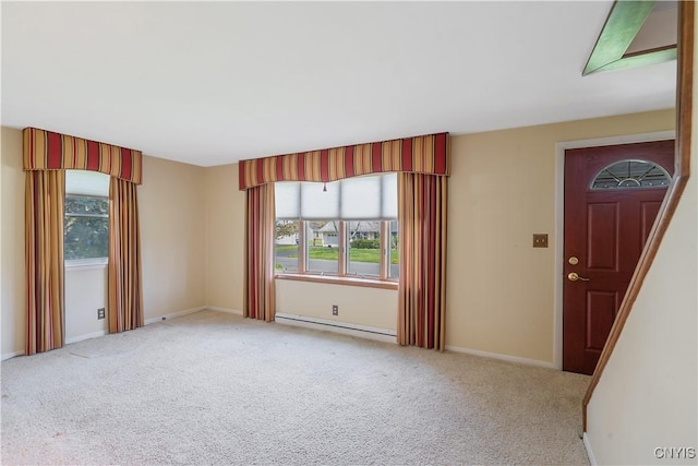 carpeted spare room featuring baseboards, plenty of natural light, and baseboard heating