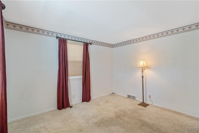 carpeted spare room featuring visible vents and baseboards