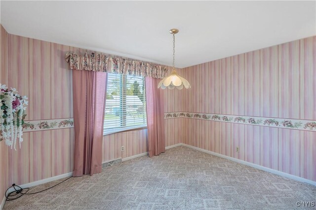 carpeted spare room featuring wallpapered walls, visible vents, and baseboards
