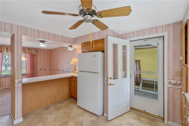 kitchen with freestanding refrigerator and wallpapered walls