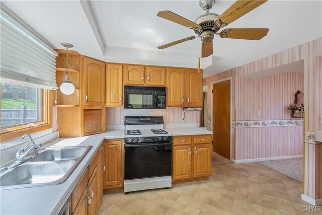 kitchen with black microwave, a sink, light countertops, a ceiling fan, and gas range
