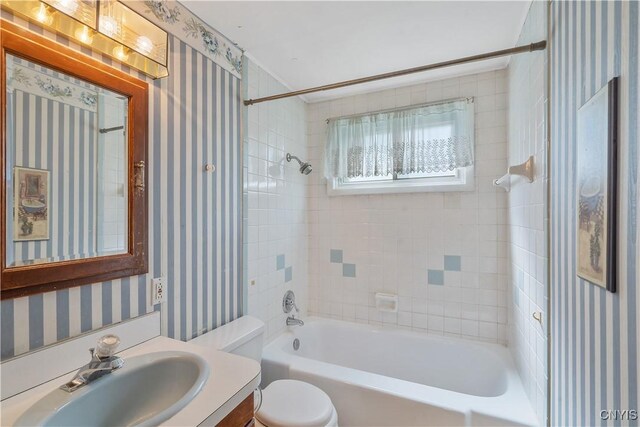 bathroom featuring washtub / shower combination, wallpapered walls, vanity, and toilet